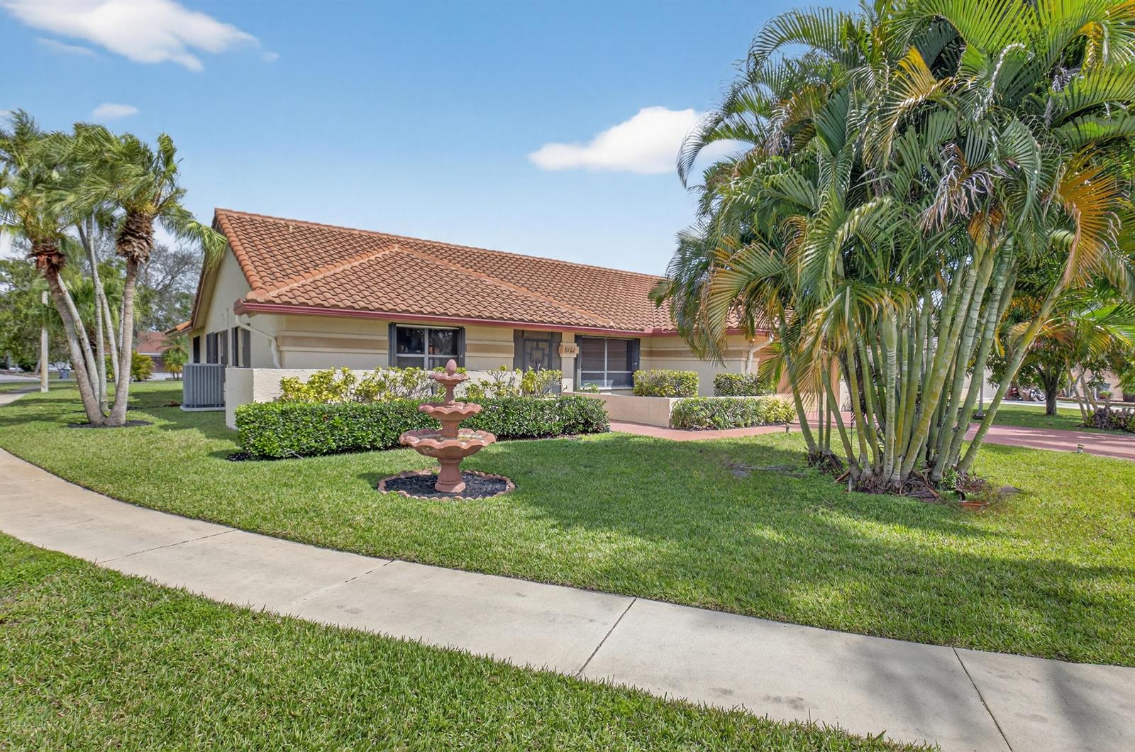 A single-story house with a tiled roof, a front fountain, and palm trees on the lawn — 9362 Laurel Green Drive, Boynton Beach FL 33437, BOYNTON BEACH, FL