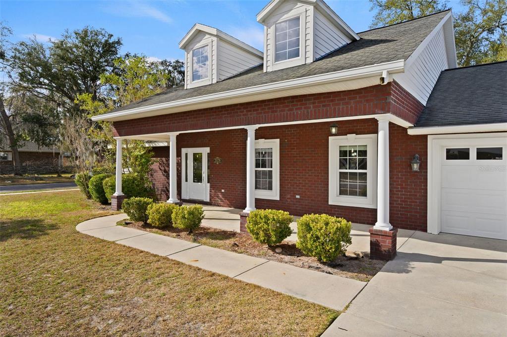 A one-story brick house with a front porch, white columns, and two dormer windows — 25178 SW 20TH AVENUE, NEWBERRY, FL