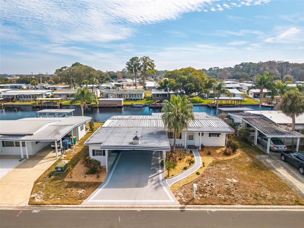 An aerial view of a waterfront mobile home with a carport and a metal roof — 1018 SOUTHLAND DRIVE, TAVARES, FL