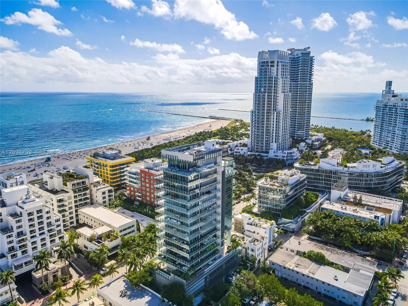 An aerial view shows a modern glass high-rise building surrounded by coastal city architecture — 120 Ocean Dr # 700, Miami Beach FL 33139, MIAMI BEACH, FL