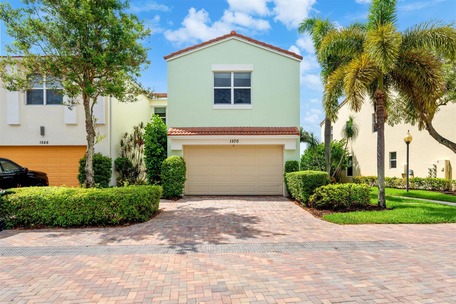 A two-story light green house with a tan garage door and a brick driveway — 1570 NW 48th Place, Boca Raton FL 33431, BOCA RATON, FL