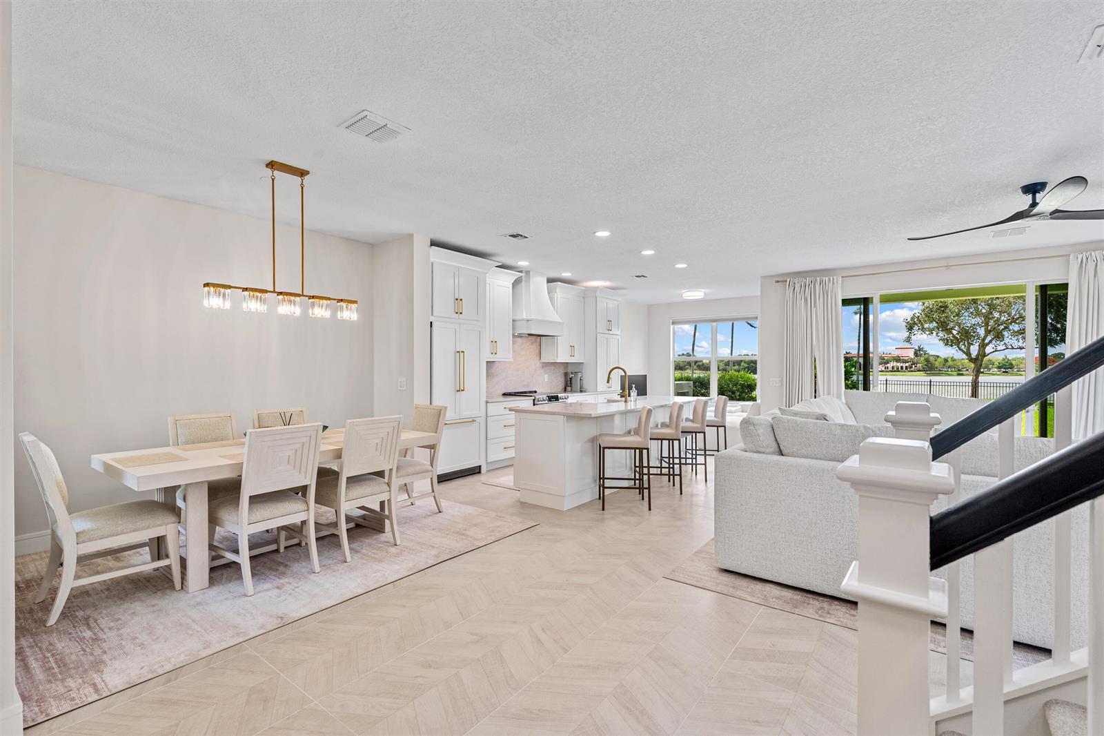 An open-concept kitchen and dining area features white cabinetry, light wood flooring, and a view — 1570 NW 48th Place, Boca Raton FL 33431, BOCA RATON, FL