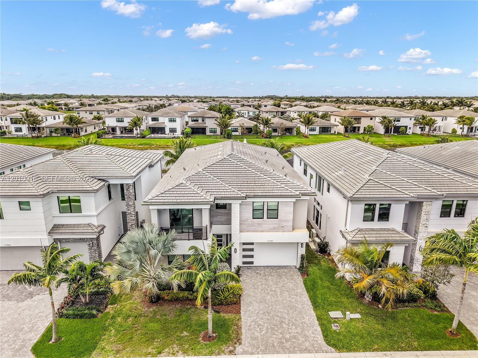 An aerial view shows three modern two-story houses with tiled roofs and paved driveways — 17197 Teton River Rd, Boca Raton FL 33496, BOCA RATON, FL