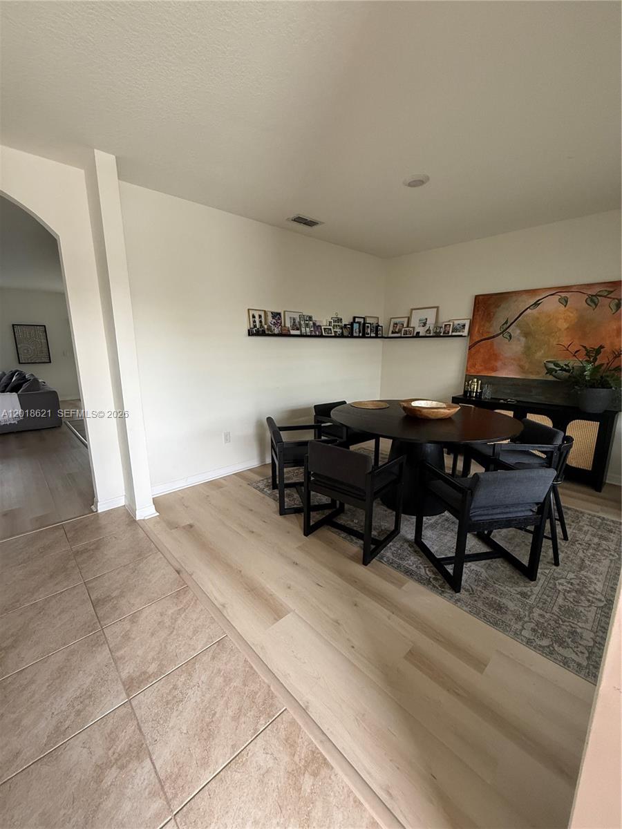 A dining area features a round table, dark chairs, a rug, and a wall-mounted shelf — 1630 Reddish Egret, Davenport FL 33897, DAVENPORT, FL