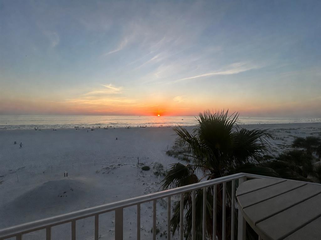 An exterior view of a multi-story yellow apartment building with balconies and a small pool — 15 SOMERSET STREET UNIT 4A, CLEARWATER BEACH, FL