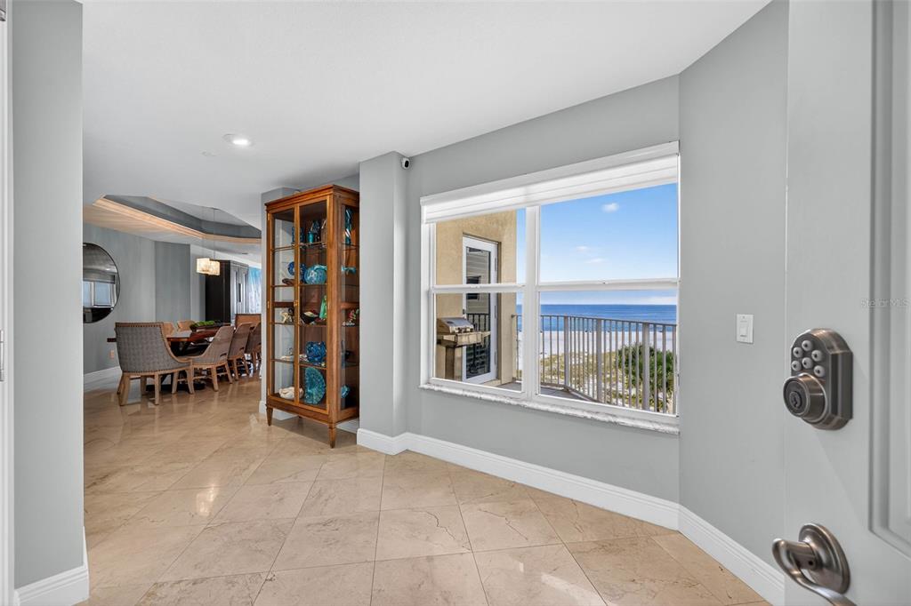 A foyer features light blue walls, tile flooring, a console table, and a numbered door — 15 SOMERSET STREET UNIT 4A, CLEARWATER BEACH, FL