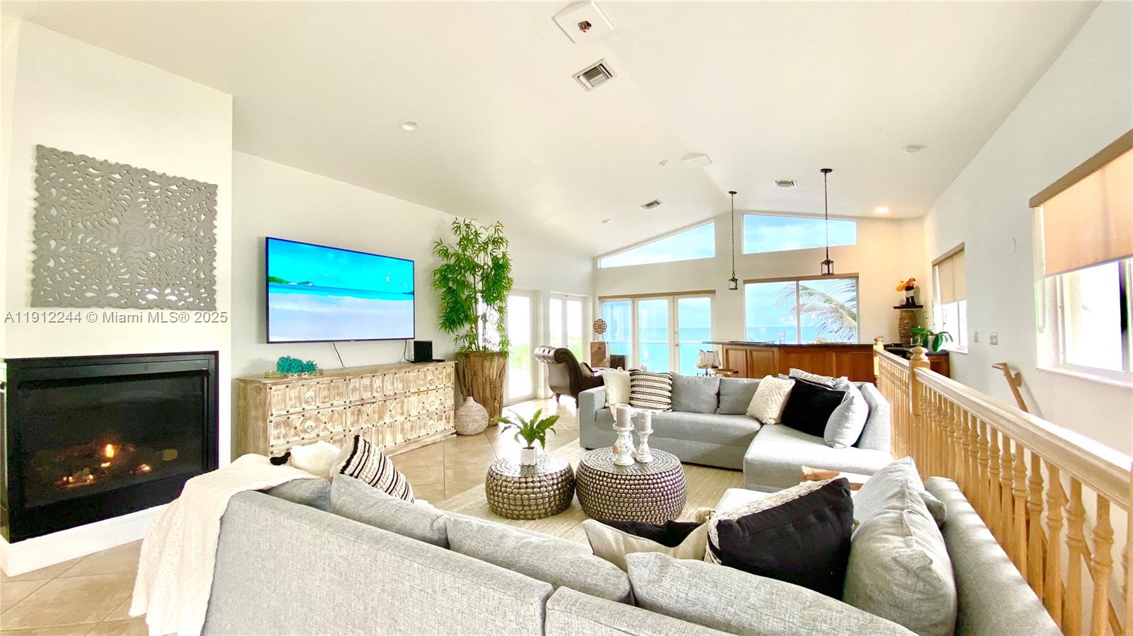 A living room features a fireplace, a large television, and a view of the ocean — 302 Balboa St # 0, Hollywood FL 33019, HOLLYWOOD, FL