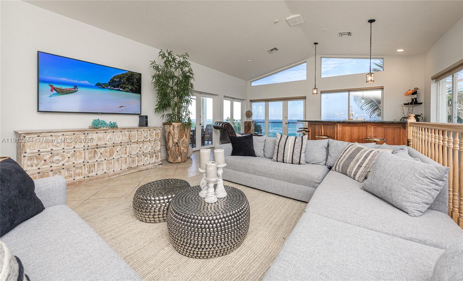 A living room features a large sectional sofa, a television, and views of the ocean — 302 Balboa St # 0, Hollywood FL 33019, HOLLYWOOD, FL