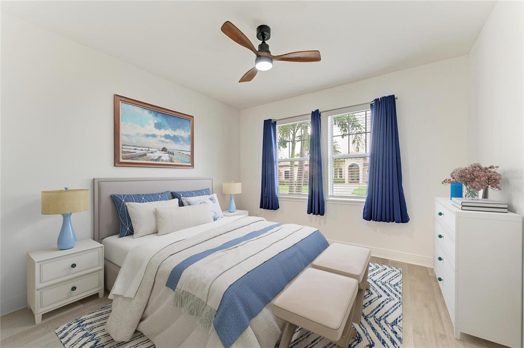 A bedroom features a bed with blue accents, two nightstands, and a ceiling fan — 4809 TOBERMORY WAY, BRADENTON, FL