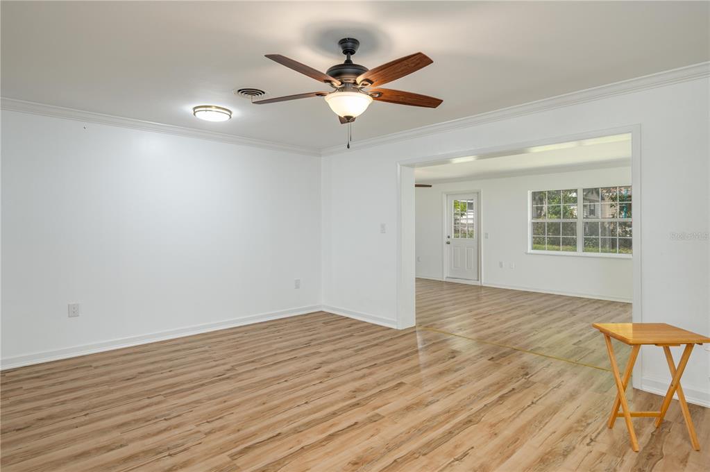 An interior view of a room with light wood-look flooring, white walls, and a ceiling fan — 2230 W HELEN CIRCLE, BARTOW, FL