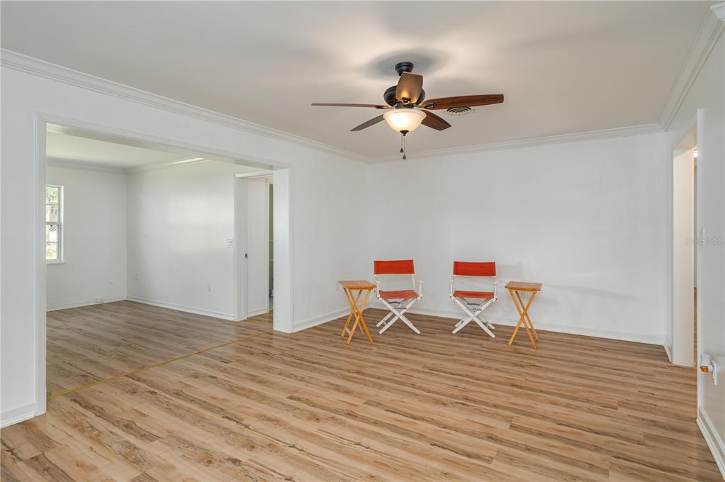 A bright room features light wood-look flooring, white walls, a ceiling fan, and two chairs — 2230 W HELEN CIRCLE, BARTOW, FL