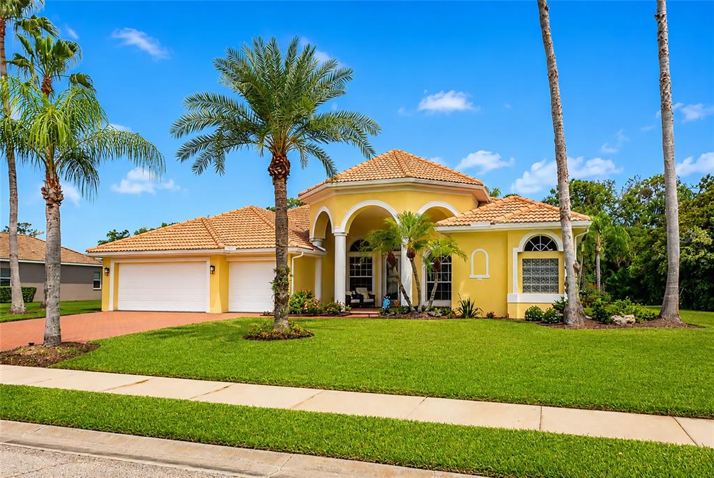 A yellow single-story house with a tile roof and a two-car garage — 14711 2ND AVENUE CIRCLE NE, BRADENTON, FL