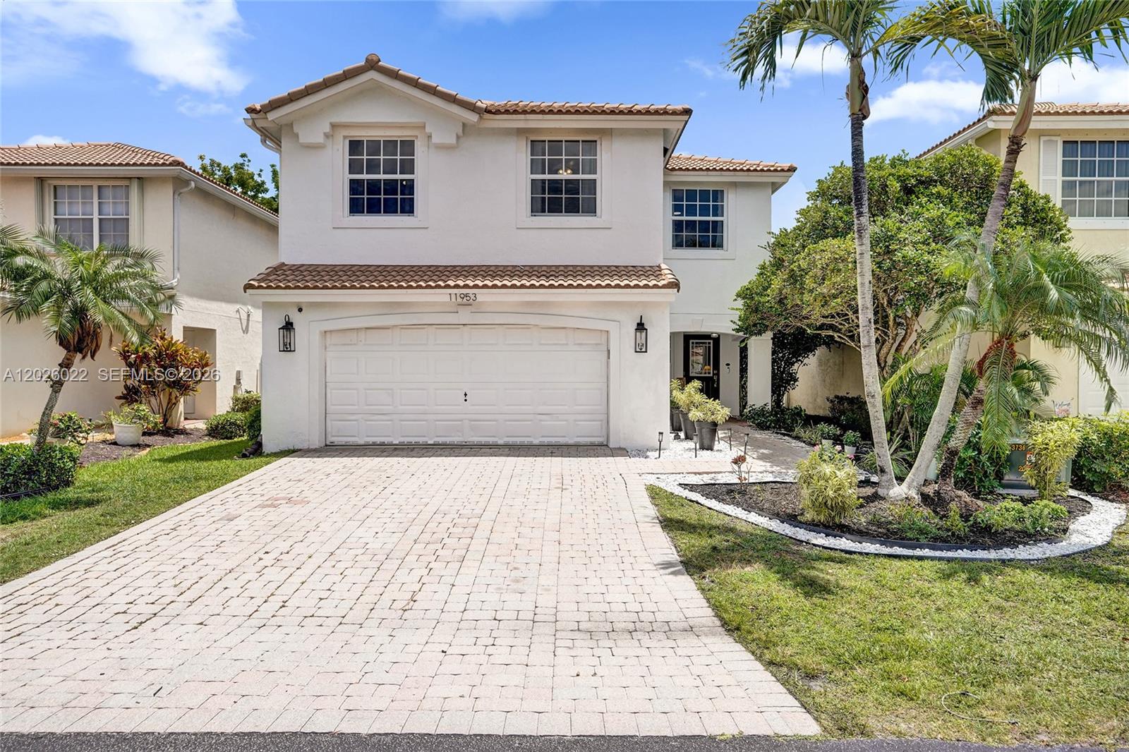A two-story house with a white stucco exterior, tile roof, and a paved driveway — 11953 Donlin Dr, Wellington FL 33414, WELLINGTON, FL