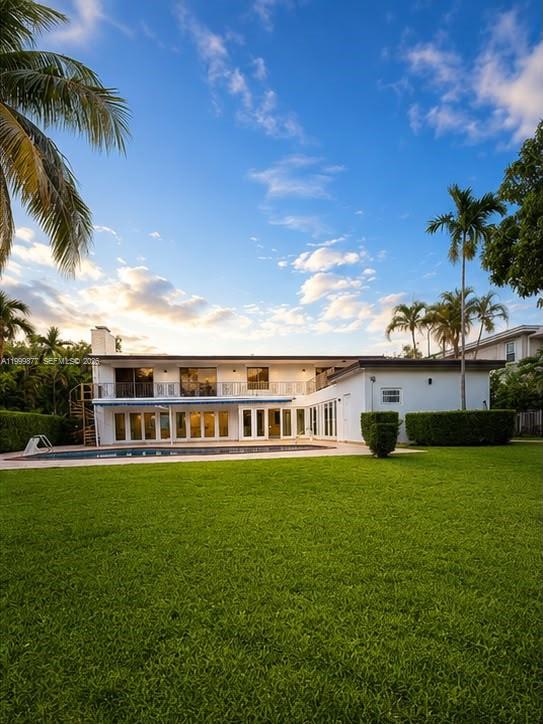 A two-story white house with a pool and large lawn under a blue sky — 4403 Palm Ln, Miami FL 33137, MIAMI, FL