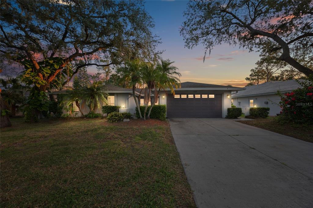 A single-story house with a concrete driveway and a two-car garage at sunset — 4369 MARINE PARKWAY, NEW PORT RICHEY, FL