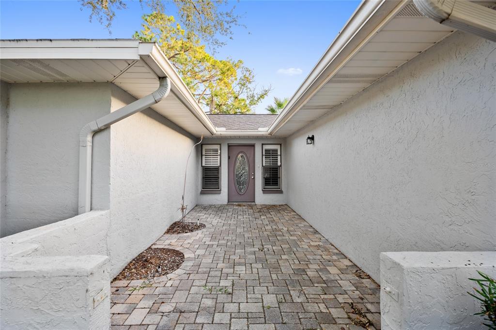 A paved walkway leads to a front entrance with a decorative glass door — 4369 MARINE PARKWAY, NEW PORT RICHEY, FL