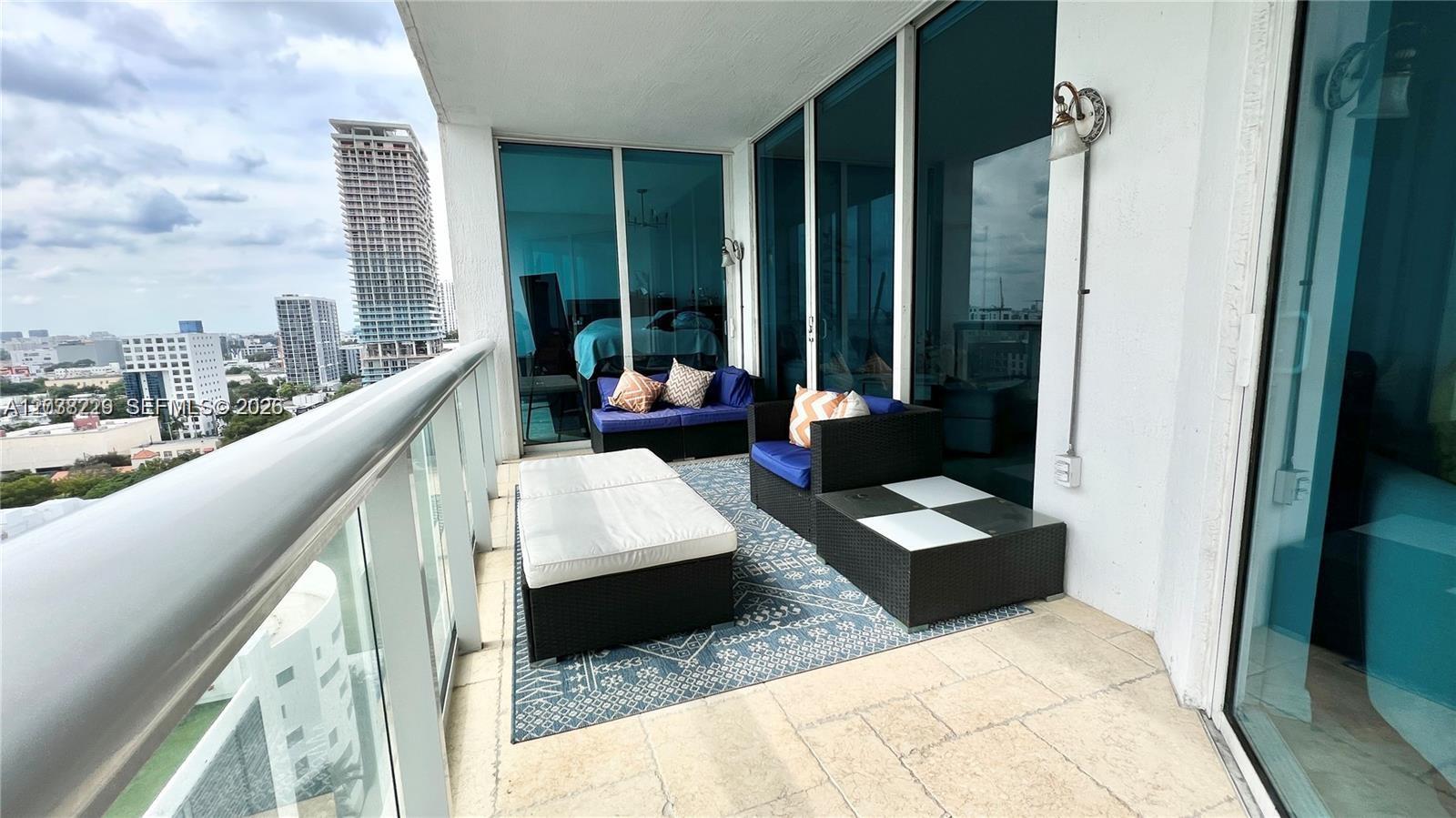 A balcony with outdoor furniture, a patterned rug, and a view of city buildings — 480 NE 30th St # 1603, Miami FL 33137, MIAMI, FL