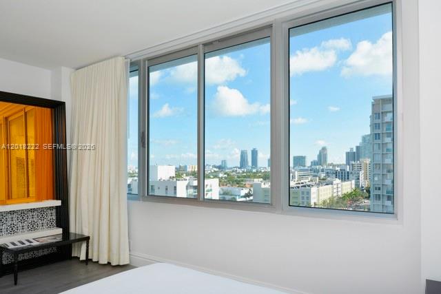 A bedroom features a large window with city views and a black-framed mirror — 1100 West Ave # 425, Miami Beach FL 33139, MIAMI BEACH, FL