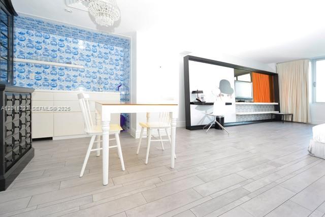 A dining area with a white table and chairs sits before a blue-tiled wall — 1100 West Ave # 425, Miami Beach FL 33139, MIAMI BEACH, FL