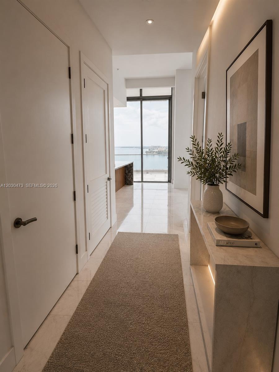 A bright hallway with marble floors leads to a balcony overlooking a body of water — 175 SE 25th rd # 1503, Miami FL 33129, MIAMI, FL