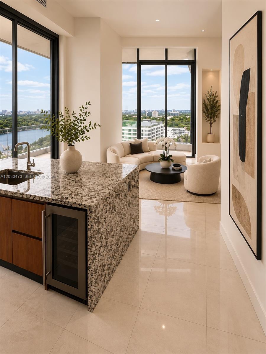 A kitchen island with granite countertops overlooks a living area with floor-to-ceiling windows — 175 SE 25th rd # 1503, Miami FL 33129, MIAMI, FL