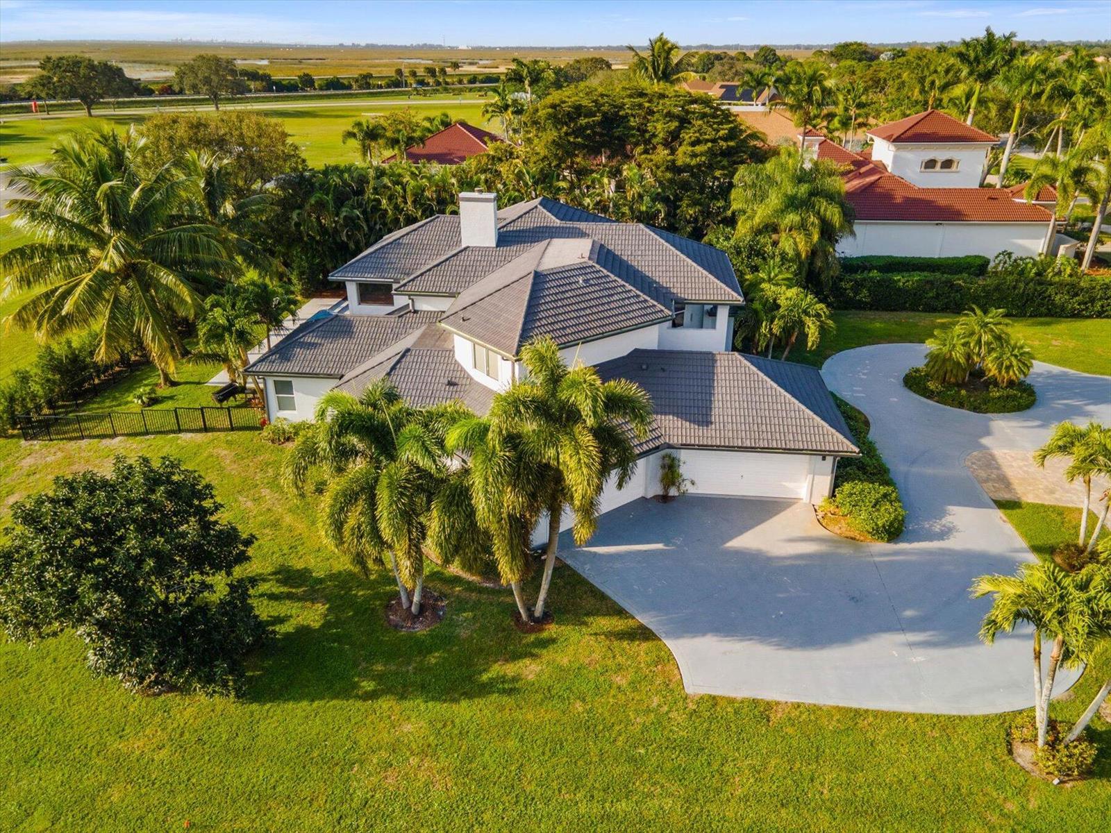 An aerial view of a two-story house with a grey tile roof and circular driveway — 2135 Windsock Way, Wellington FL 33414, WELLINGTON, FL