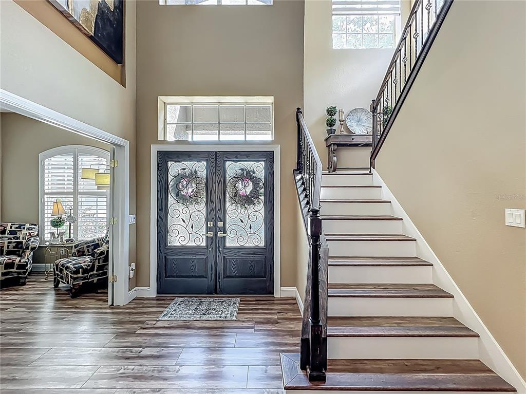 A foyer features a double front door, a staircase with wood treads, and tile flooring — 3008 SUTTON WOODS DRIVE, PLANT CITY, FL