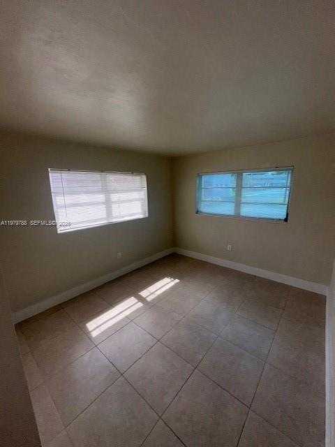 An empty room with beige walls, tile flooring, and two windows with white blinds — 7500 SW 82nd St # G110, Miami FL 33143, MIAMI, FL