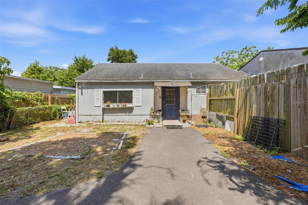 A single-story house with gray siding, a dark blue front door, and a paved driveway — 2706 E ANNIE STREET, TAMPA, FL