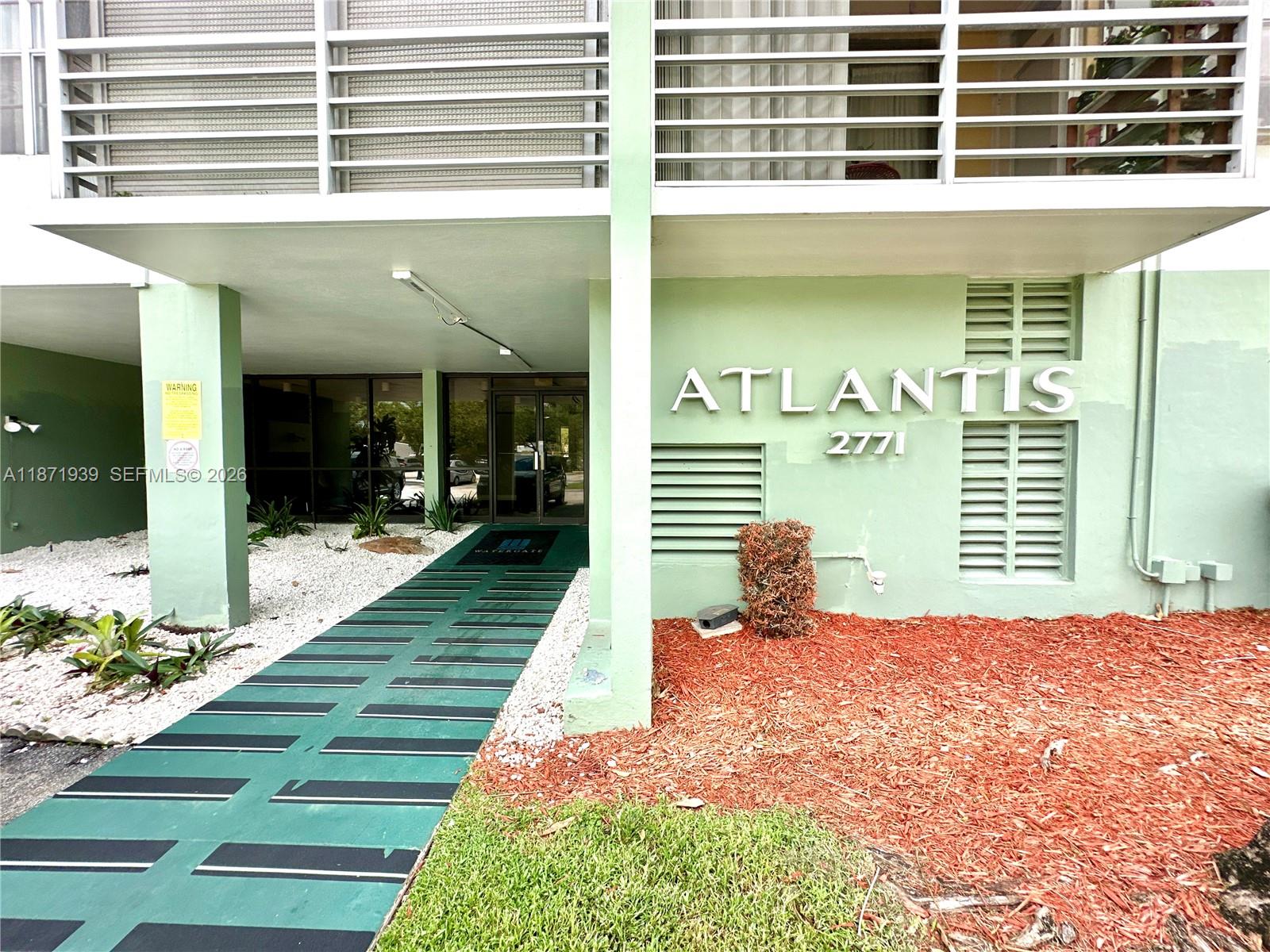 The exterior of a building features a green facade with the name Atlantis displayed prominently — 2771 Taft St # 302, Hollywood FL 33020, HOLLYWOOD, FL