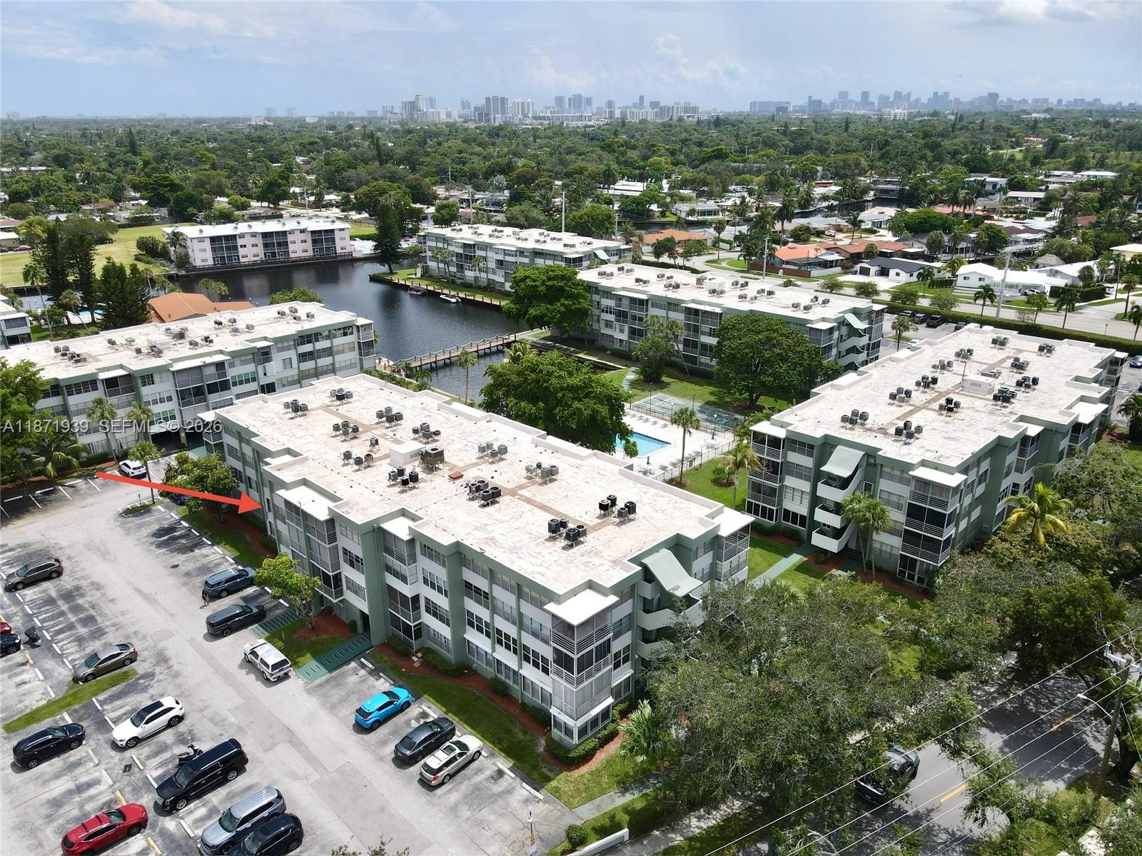 An aerial view shows multi-story apartment buildings with flat roofs, parking lots, and a pool — 2771 Taft St # 302, Hollywood FL 33020, HOLLYWOOD, FL