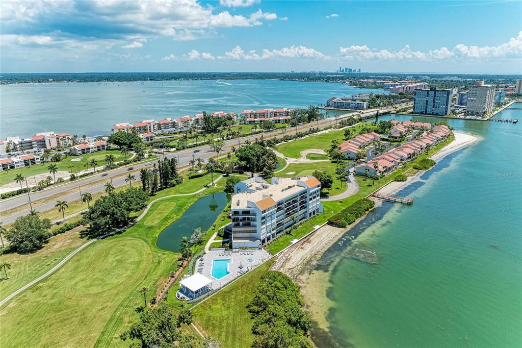 An aerial view of a waterfront condominium complex with a pool and golf course — 5700 ESCONDIDA BOULEVARD S UNIT 506, ST PETERSBURG, FL