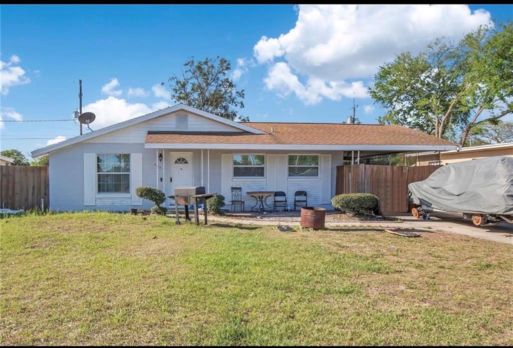 A single-story house with a light gray exterior, a brown roof, and a covered carport — 5108 FIGWOOD LANE, ORLANDO, FL