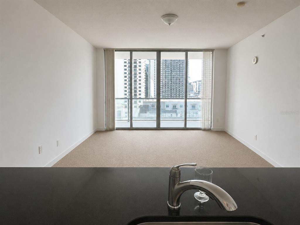 A view from a kitchen sink looking toward a living area with floor-to-ceiling windows — 1111 SW 1ST AVENUE UNIT 1924, MIAMI, FL