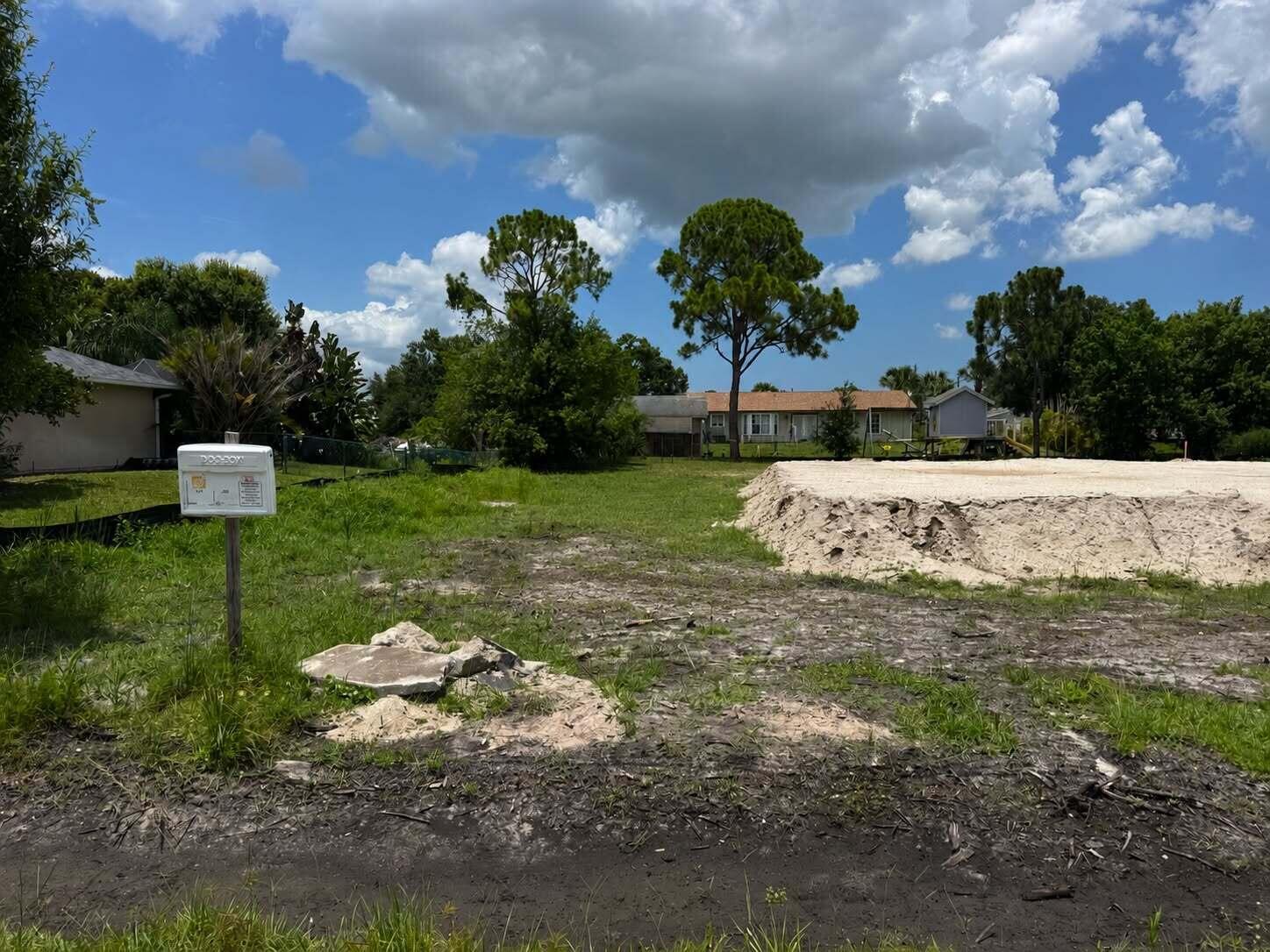 A vacant lot features a large pile of sand and a white mailbox in the foreground — 9036 86th Street, Vero Beach FL 32967, VERO BEACH, FL