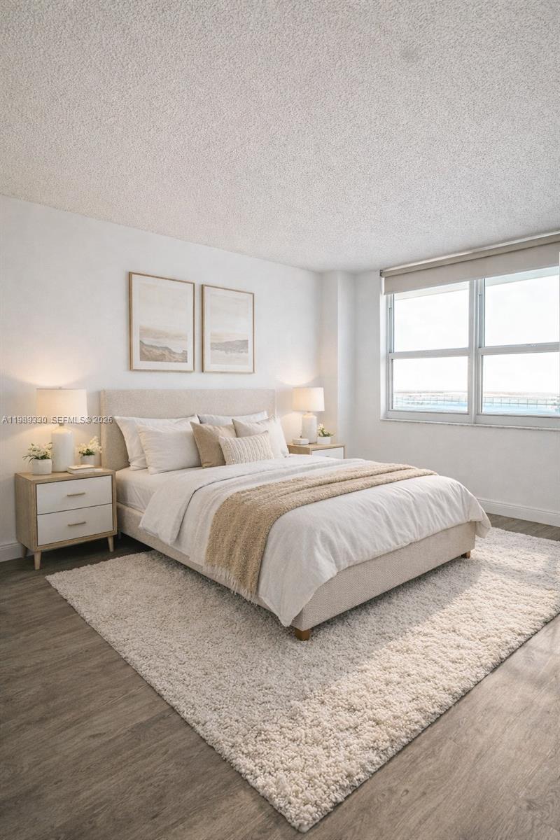 A bedroom features a neutral color palette, a textured area rug, and a large window — 1155 Brickell Bay Dr # 1705, Miami FL 33131, MIAMI, FL