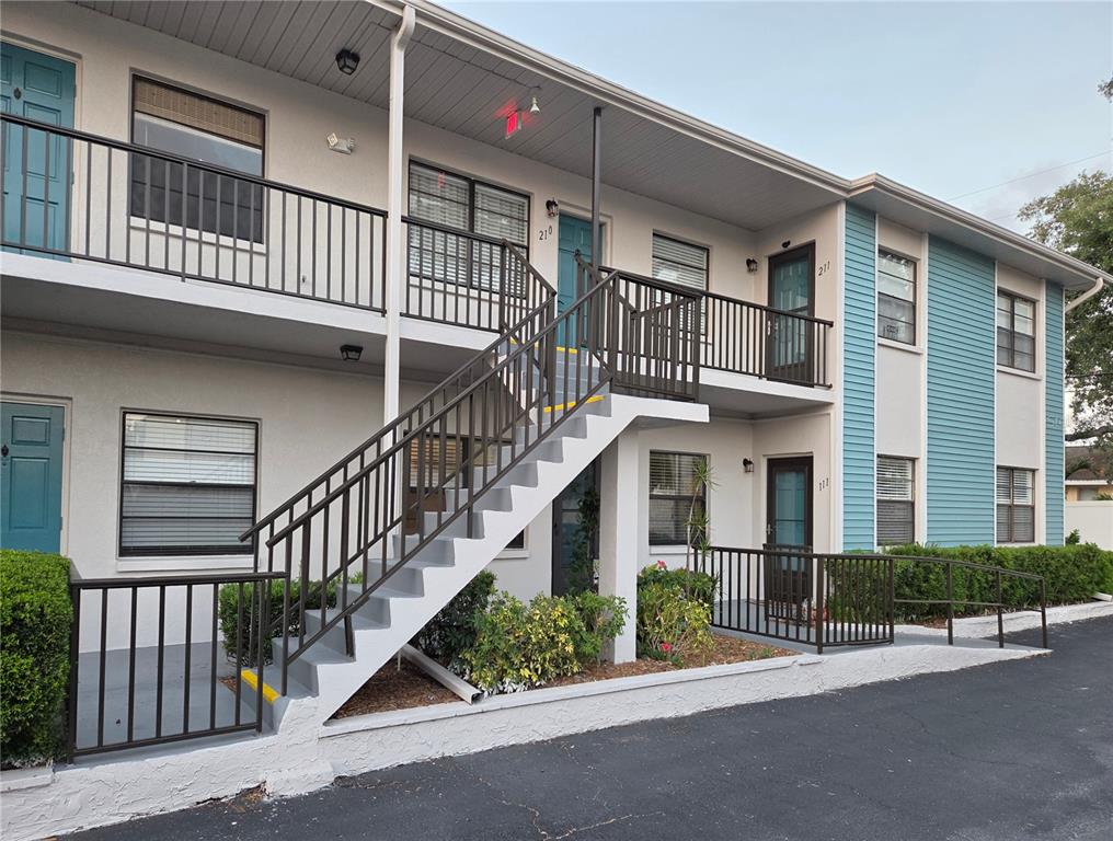 A rectangular hot tub sits in the foreground with a larger swimming pool behind it — 5925 TERRACE PARK DRIVE N UNIT 111, ST PETERSBURG, FL