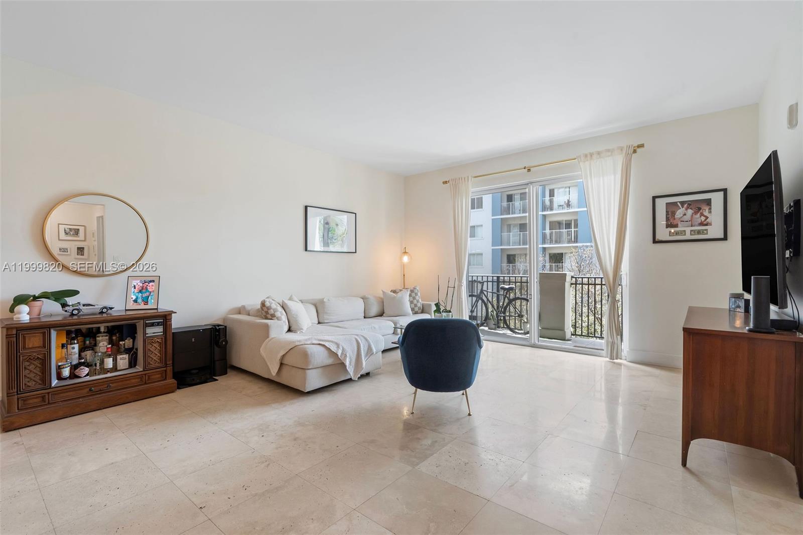 A living room features a beige sectional sofa, a blue armchair, and tile flooring — 2650 SW 37th Ave # 406, Miami FL 33133, MIAMI, FL