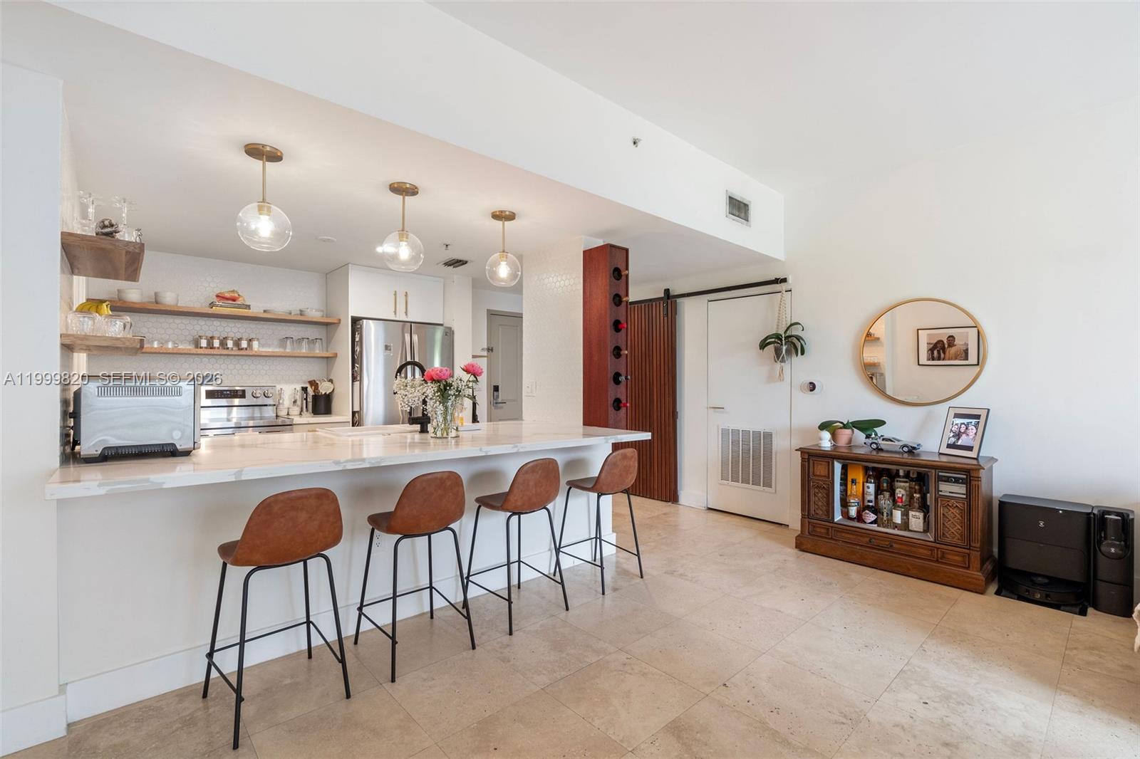 A kitchen features a marble-topped island with four bar stools and open wooden shelving — 2650 SW 37th Ave # 406, Miami FL 33133, MIAMI, FL