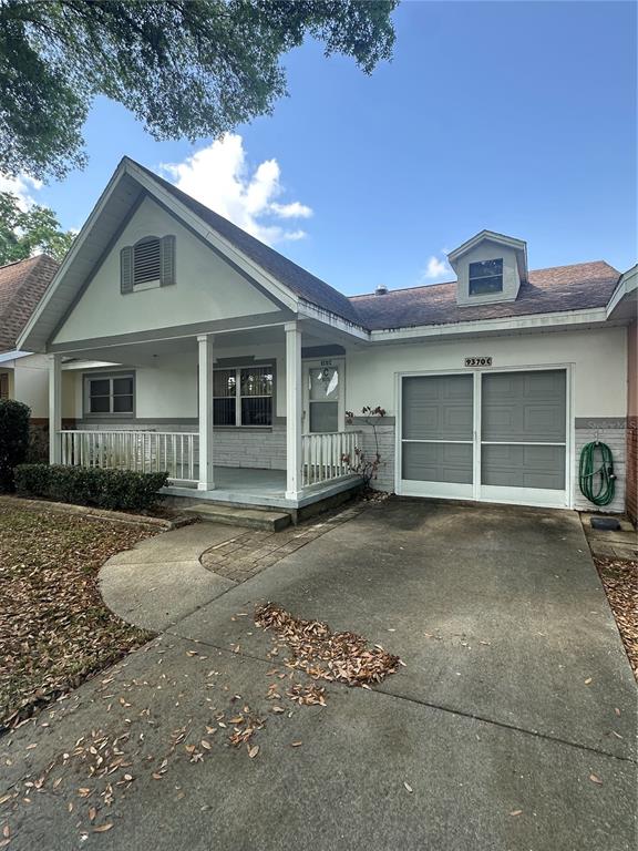 A single-story house features a covered front porch, a concrete driveway, and a garage — 9370 SW 85TH TERRACE UNIT C, OCALA, FL