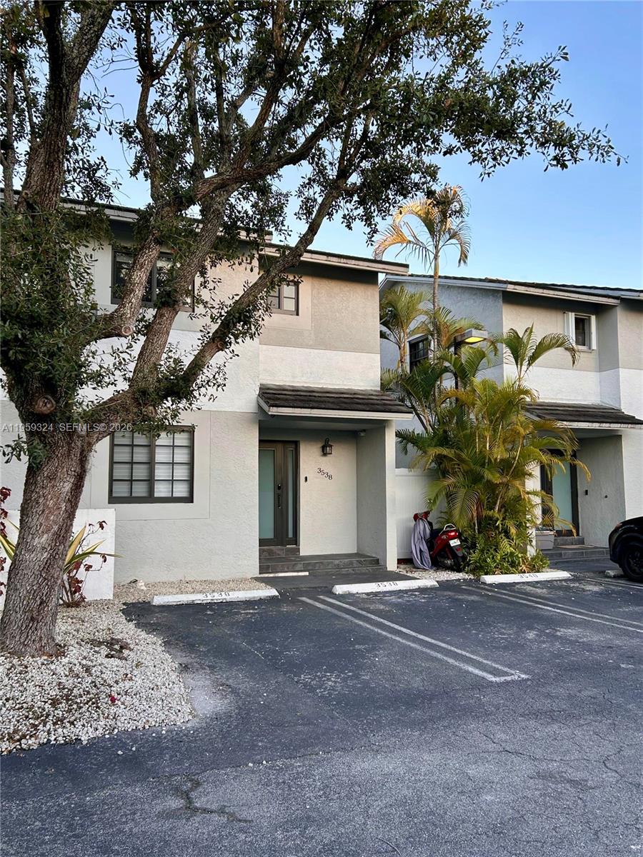 A two-story residential building with light-colored stucco walls and designated parking spaces in front — 3538 SW 17th St # 1B, Miami FL 33145, MIAMI, FL