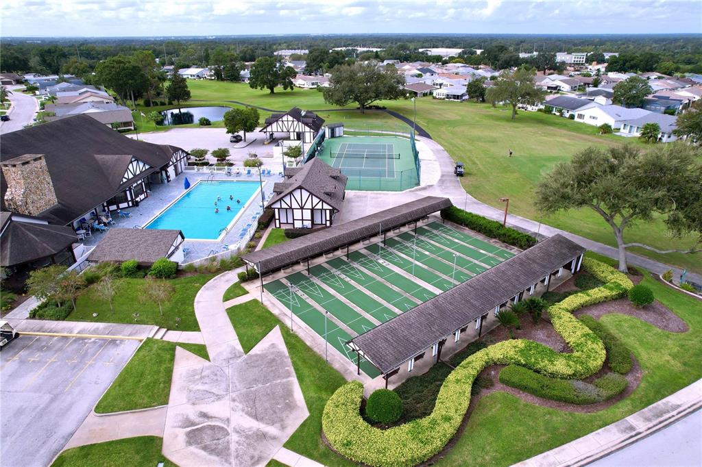 An aerial view shows a community clubhouse with a pool, tennis court, and shuffleboard courts — 2137 GRAND CYPRESS DRIVE, LAKELAND, FL