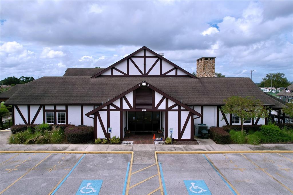 A Tudor-style building with a brown roof and white stucco exterior faces a parking lot — 2137 GRAND CYPRESS DRIVE, LAKELAND, FL