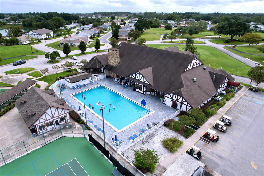 An aerial view shows a community clubhouse with a swimming pool, tennis court, and parking — 2137 GRAND CYPRESS DRIVE, LAKELAND, FL