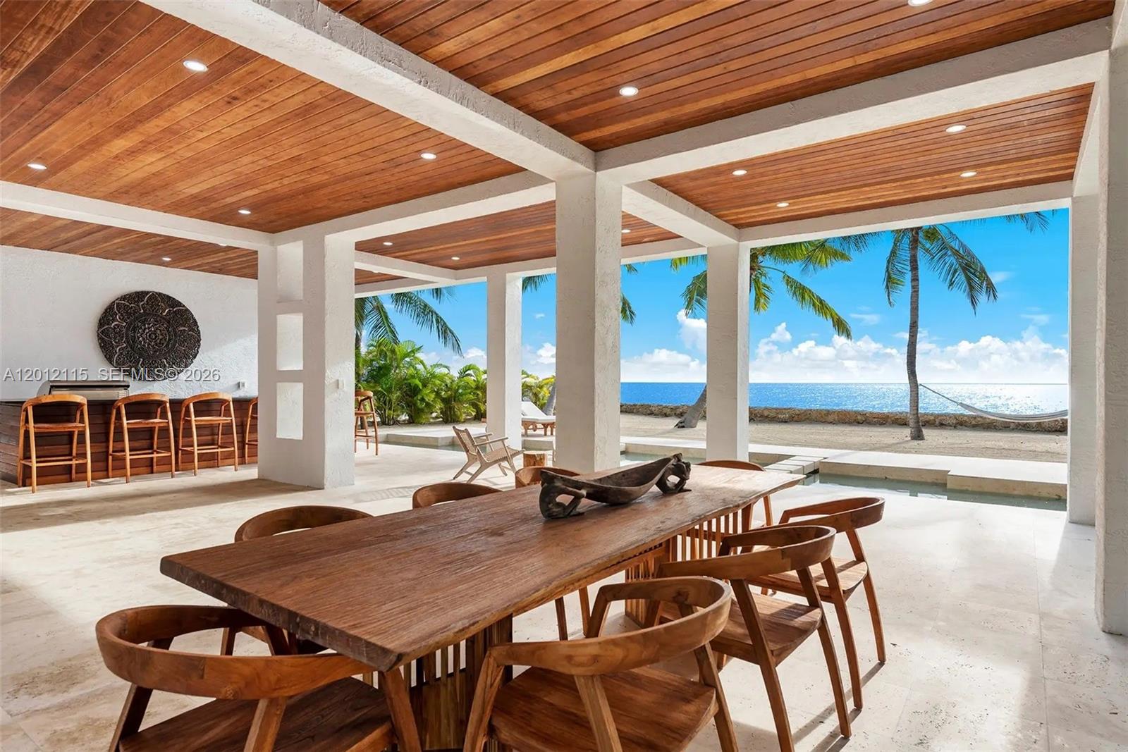 An open-air patio features a wooden dining table, a bar area, and ocean views — 60 Ocean Front Dr, Key Largo FL 33037, KEY LARGO, FL