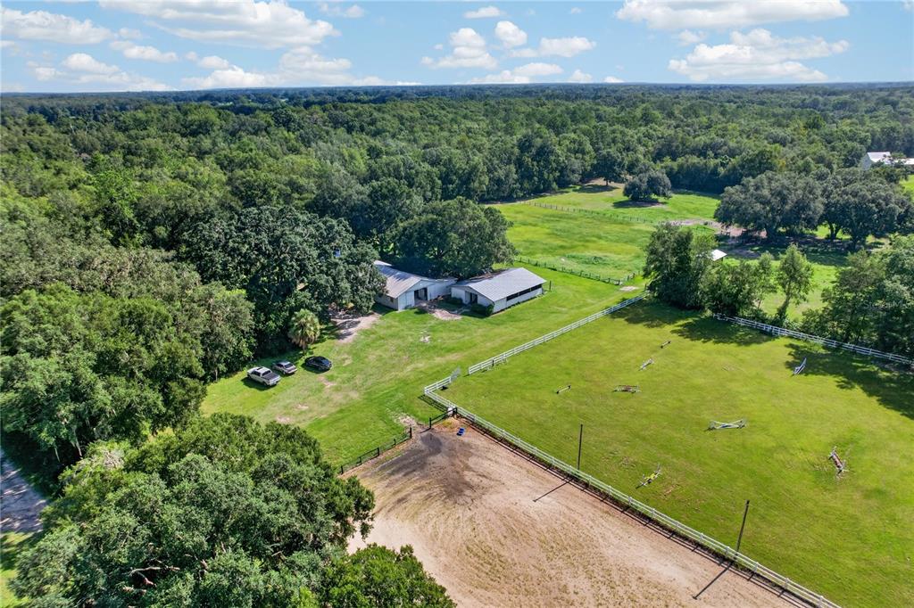 An aerial view shows a rural property with a house, outbuildings, and fenced pastures — 9813 NW STATE ROAD 45, HIGH SPRINGS, FL