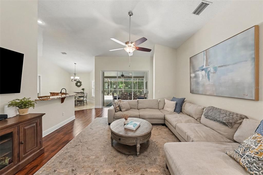 A living room features a sectional sofa, a round coffee table, and a ceiling fan — 10617 WEYBRIDGE DRIVE, TAMPA, FL