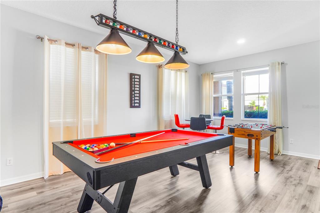 A game room features a red-felt pool table, a foosball table, and a poker hands sign — 436 ALDRIDGE LANE, DAVENPORT, FL