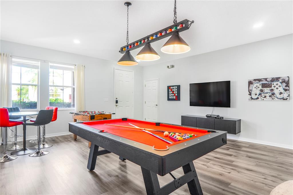 A game room features a red pool table, a foosball table, and a wall-mounted television — 436 ALDRIDGE LANE, DAVENPORT, FL