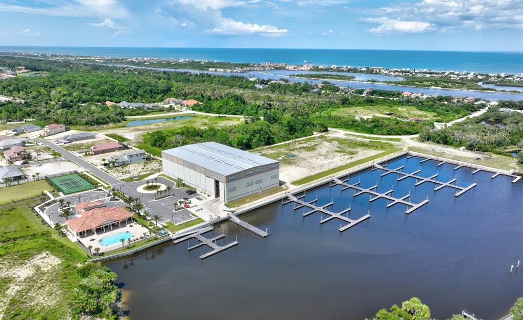 An aerial view shows a large warehouse building, a marina with boat slips, and a pool — 36 RIO VISTA DRIVE, PALM COAST, FL